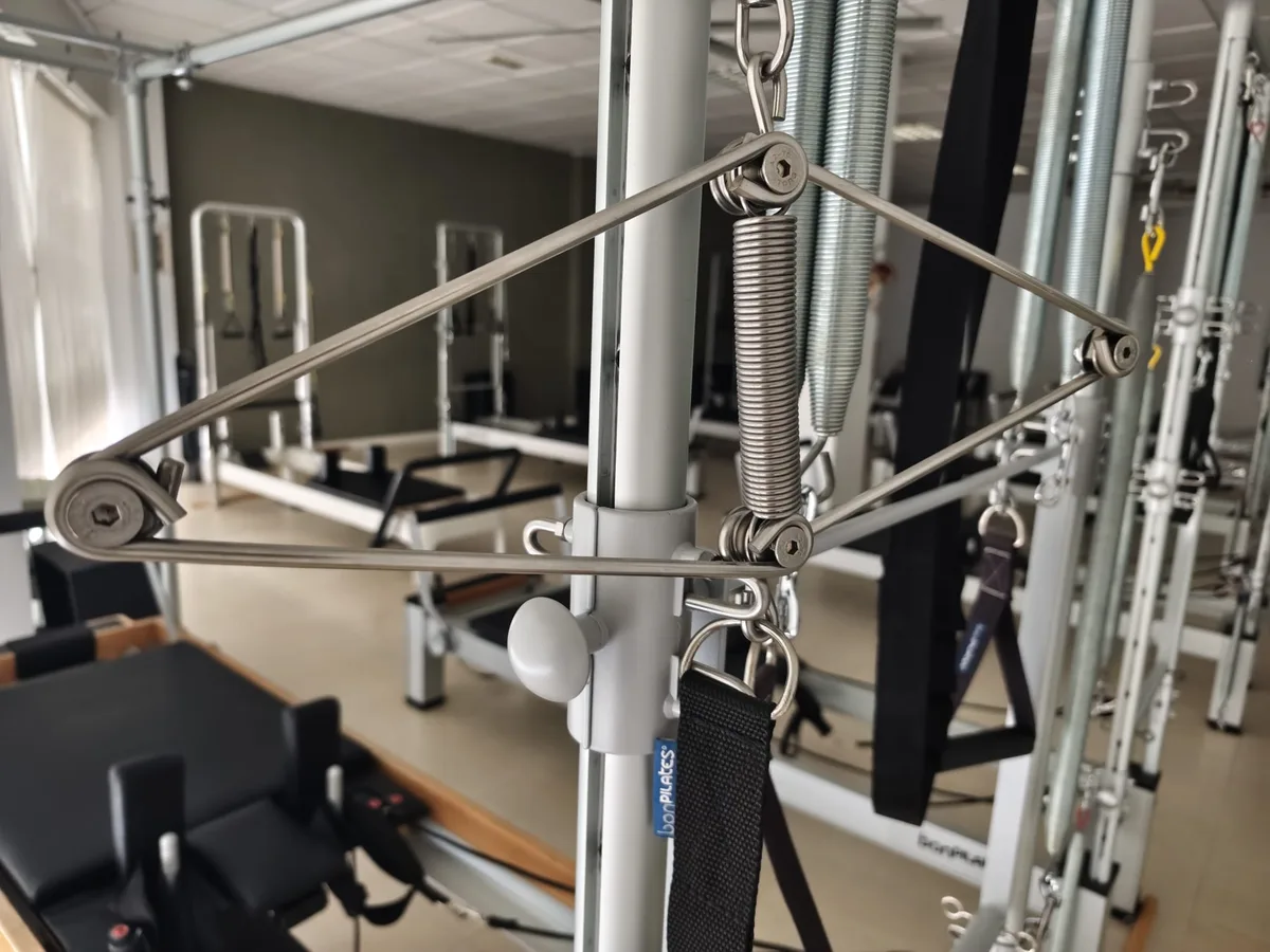 Detalle del muelle y la polea de una torre de pilates, con la marca bonPilates en la correa