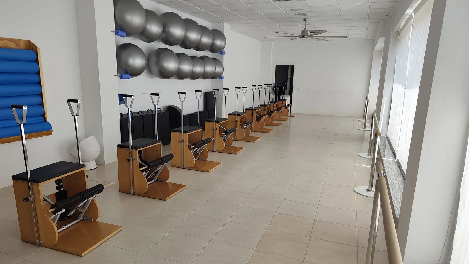 Sala de sillas del estudio: la fila de wunda chairs, los fitballs en el estante, el panel de rulos y la barra junto al ventanal